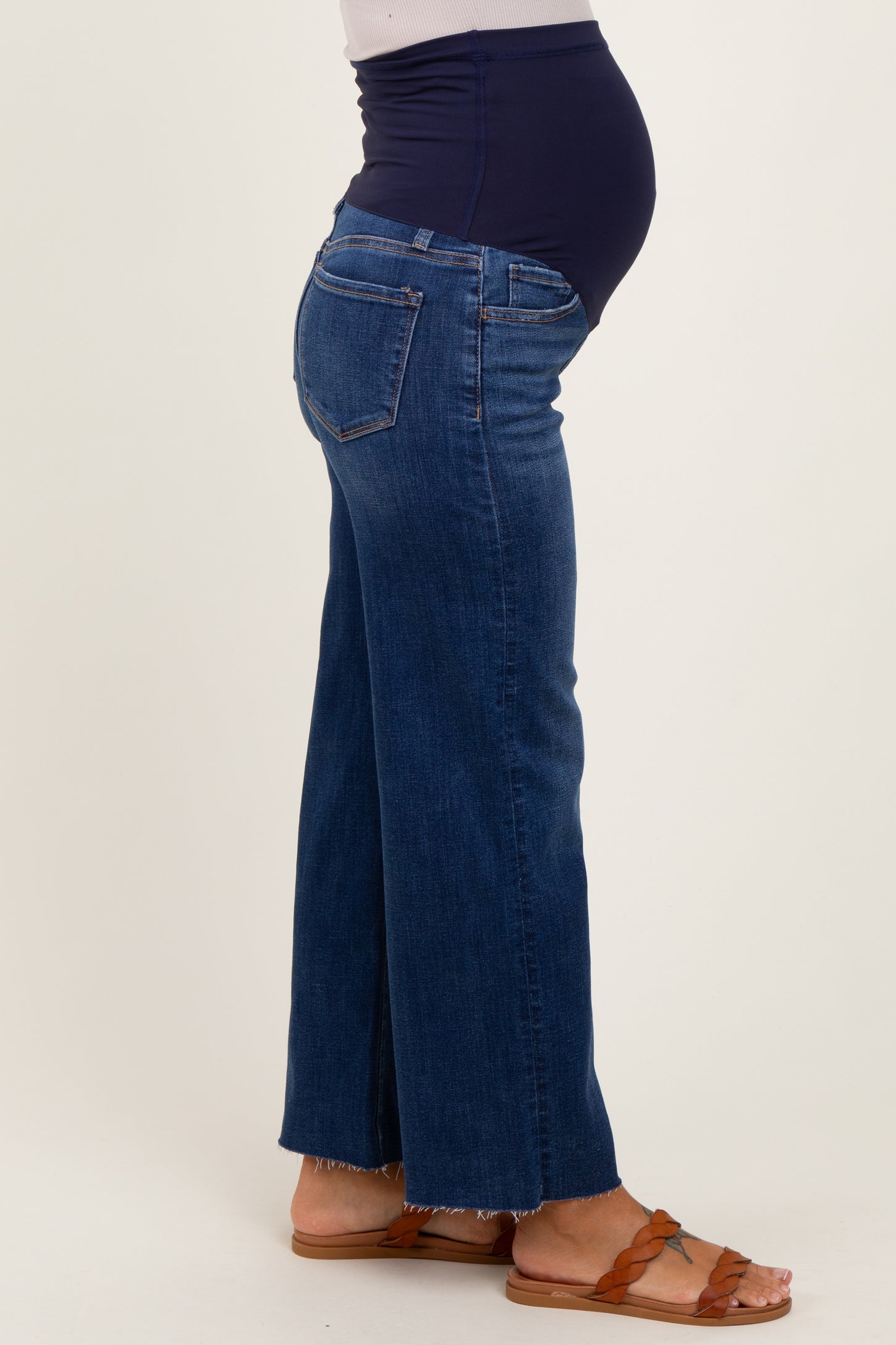 woman wearing dark blue maternity flared jeans with a stretchy navy waistband and visible baby bump