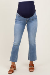 woman wearing light blue maternity jeans with a navy blue over-the-bump panel and cropped hem