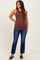 woman wearing a brown ribbed maternity tank top and blue flared maternity jeans, showing her baby bump