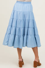 woman wearing a light blue tiered maxi skirt with an elastic waistband and brown block heel sandals