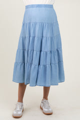 woman wearing a light blue tiered maternity skirt with an elastic waistband and paired with white sneakers