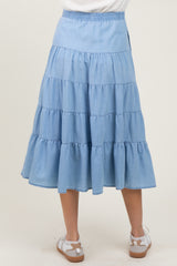 woman wearing a light blue tiered maternity skirt with an elastic waistband, viewed from the back
