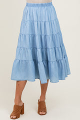 woman wearing a light blue tiered midi skirt with an elastic waistband and side pockets