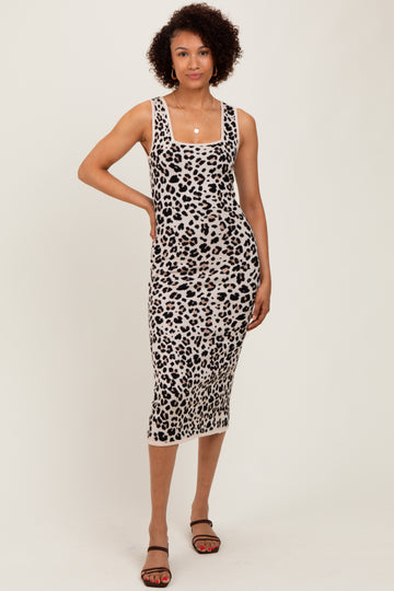 woman wearing a fitted leopard print midi dress with a square neckline and side slit, standing confidently on a plain background