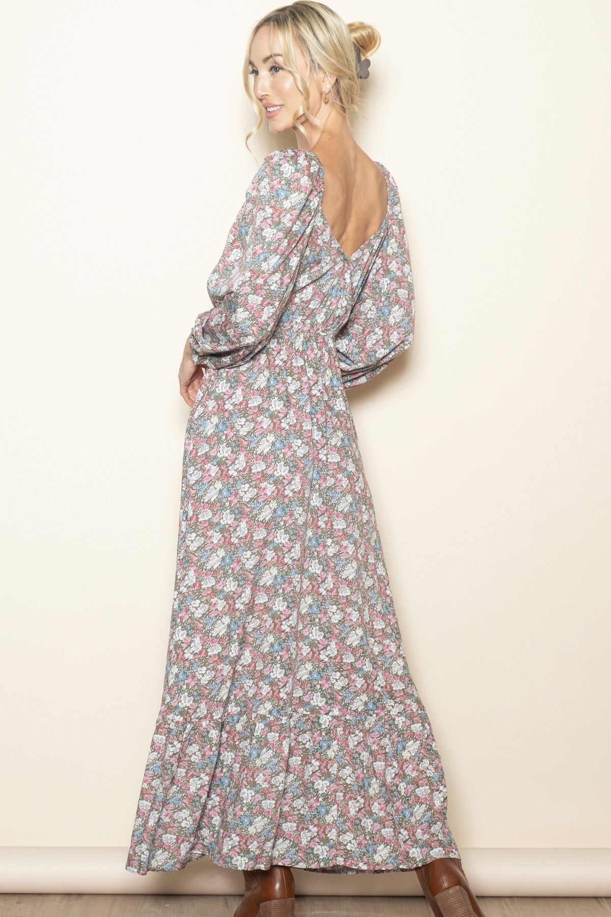 woman wearing a floral max dress with long sleeves and a deep v-back design