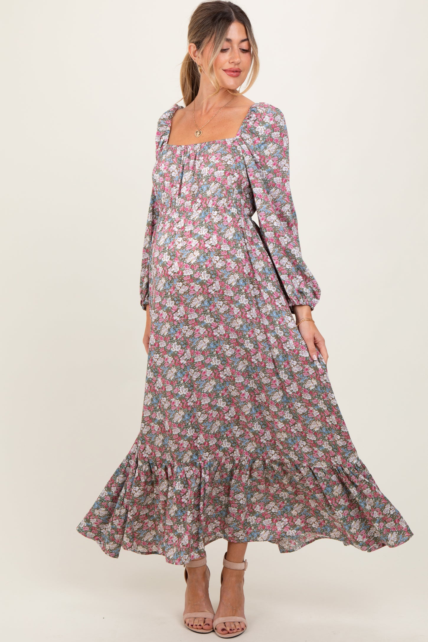 woman wearing a floral long sleeve maternity maxi dress with a square neckline and ruffled hem, showcasing her baby bump