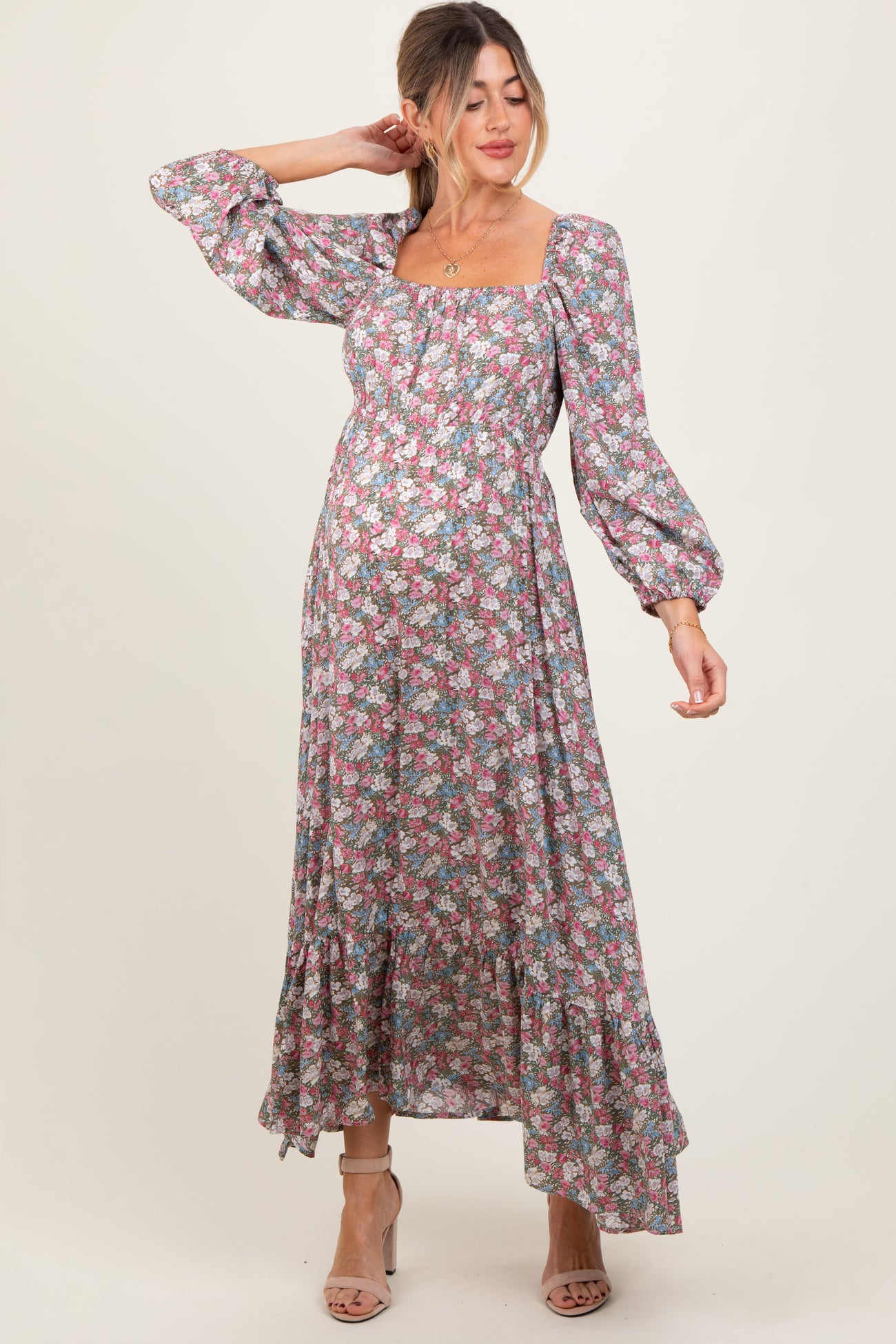 woman wearing a floral maternity maxi dress with puff sleeves and a square neckline, showcasing her baby bump