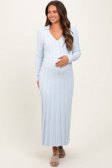 woman wearing a light blue long sleeve maternity dress with ribbed detailing and holding her baby bump