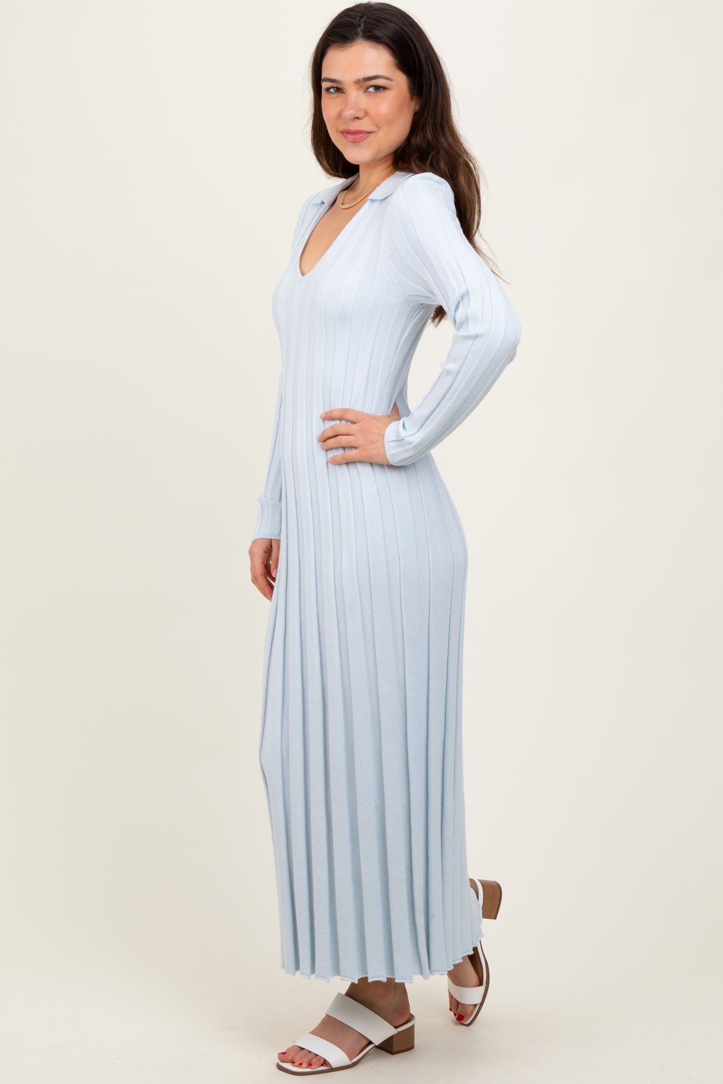woman wearing a light blue ribbed maxi dress with long sleeves and a deep v neckline