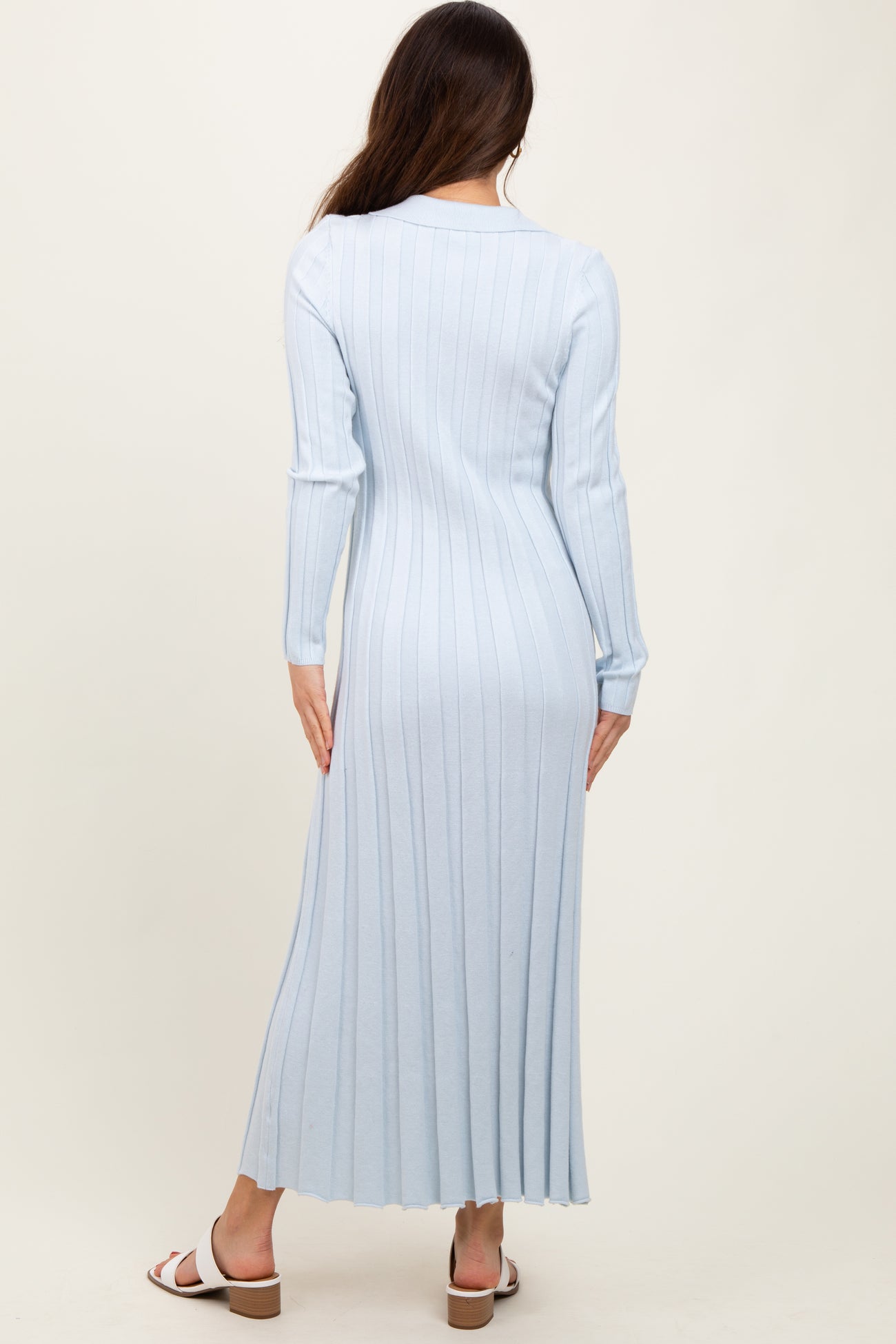 woman wearing a light blue ribbed long sleeve midi dress, view from the back