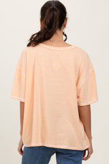 woman wearing an oversized peach t-shirt with a relaxed fit and dropped shoulders, seen from the back