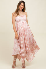 woman wearing a pink floral maternity dress with pleated details and an asymmetrical hemline, showing her baby bump