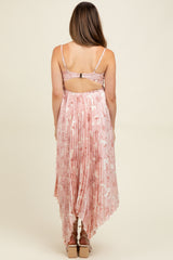 woman wearing a pink floral maternity dress with a pleated back and a high-low hemline