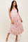 woman wearing a pink floral midi dress with a fitted bodice and flowing skirt, posing with one hand on her hip