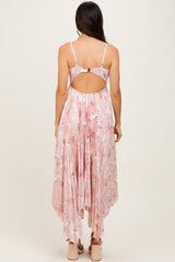 woman wearing a pink floral maxi dress with a high-low hem and open back detail