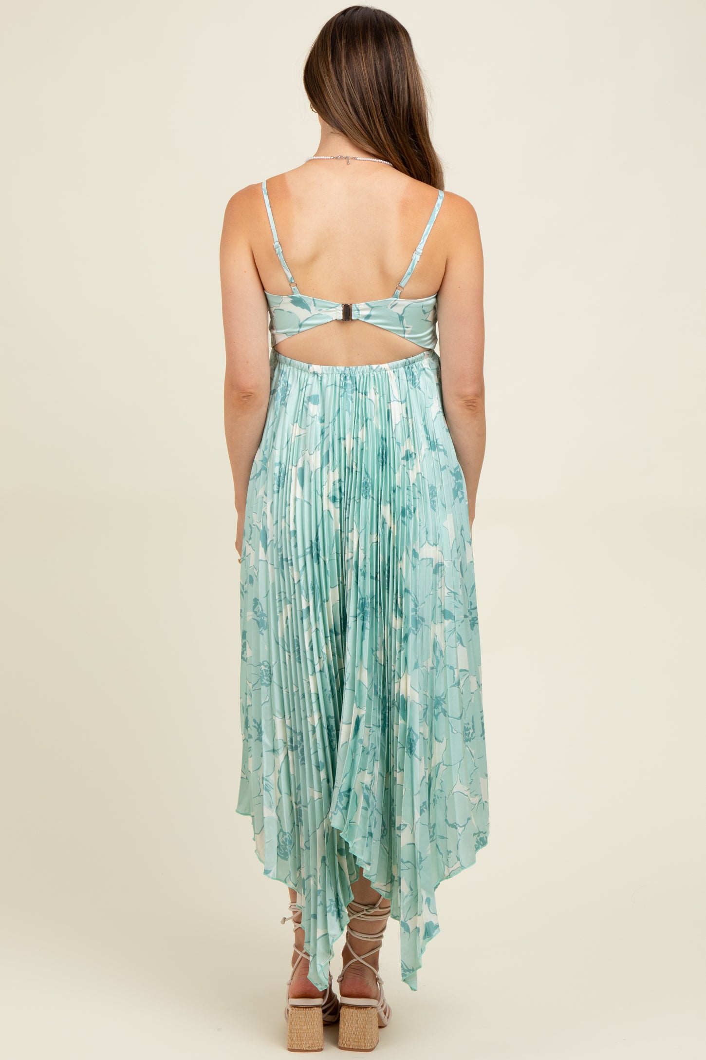 woman wearing a light green maternity dress with pleated back and spaghetti straps