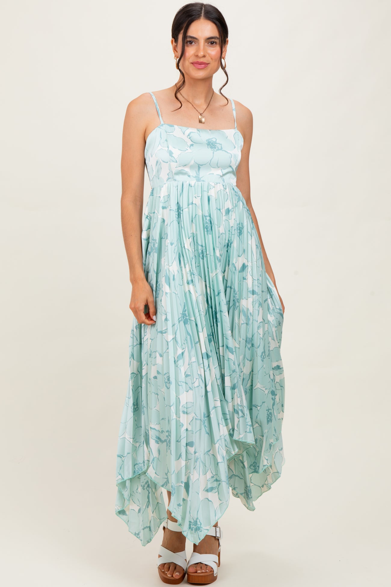 woman wearing a light blue floral print maxi dress with a flowy asymmetric hem and spaghetti straps