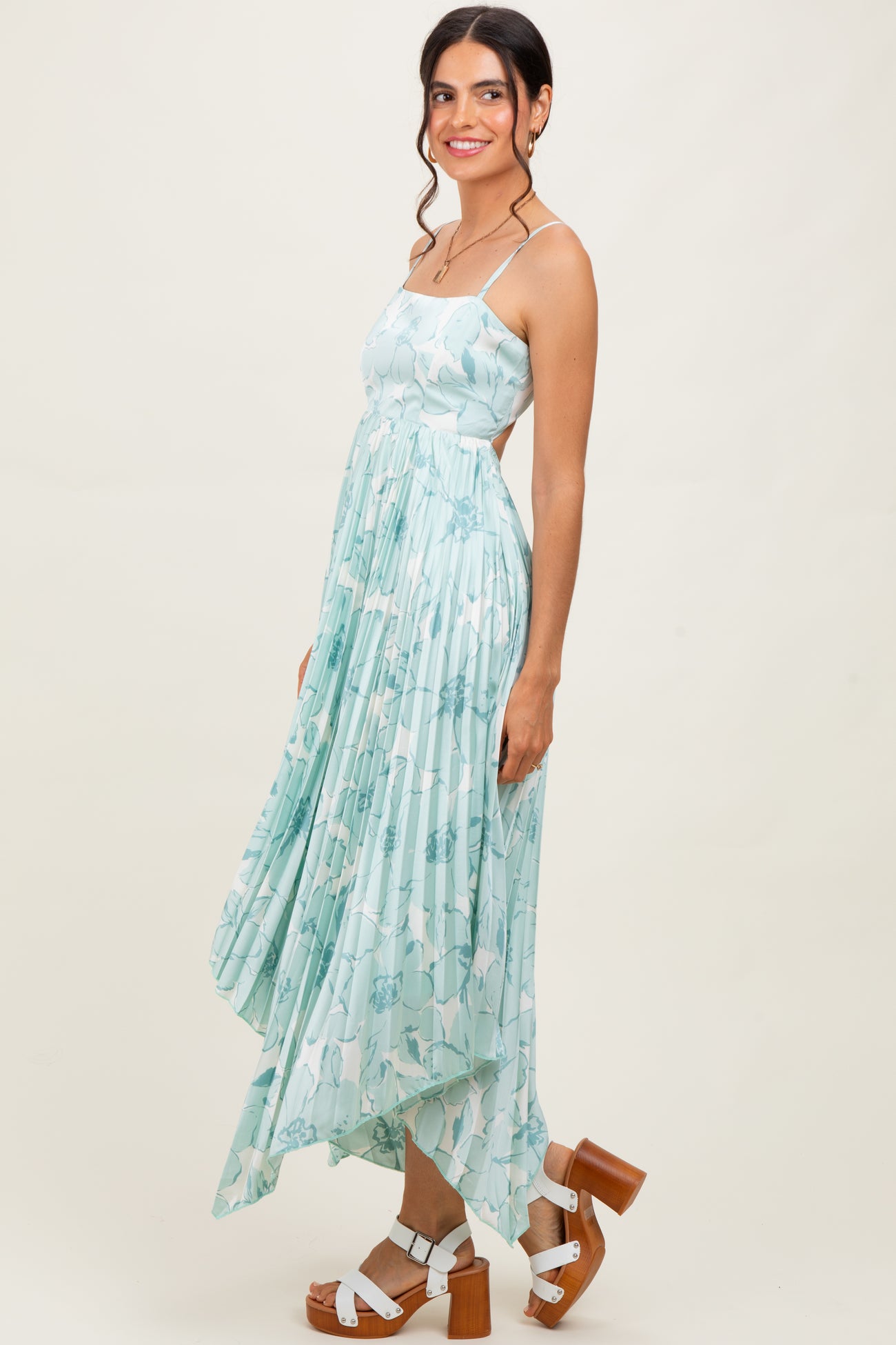 woman wearing a light blue floral print maxi dress with a high-low hem and strappy shoulders