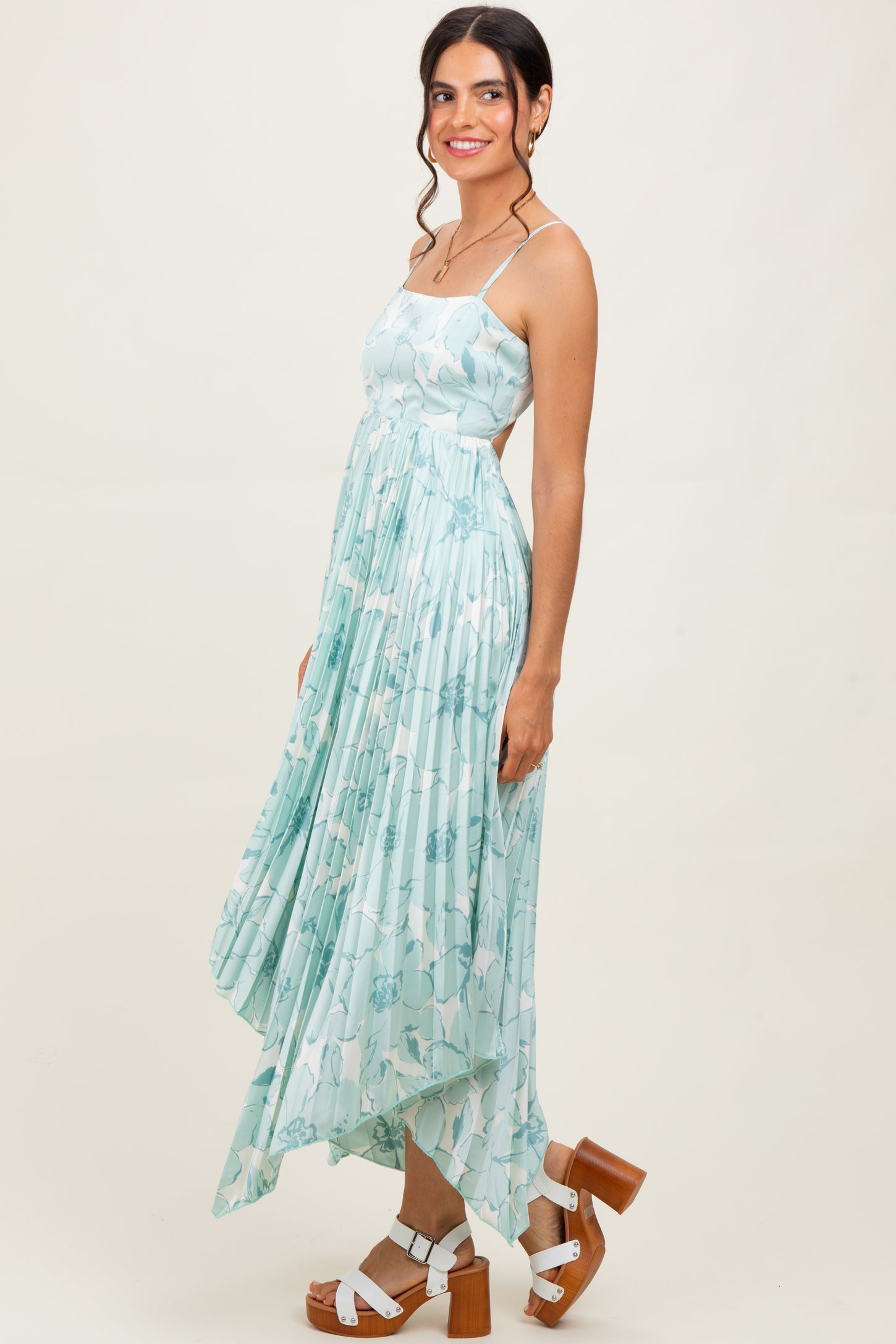 woman wearing a light blue floral print maxi dress with a high-low hem and strappy shoulders