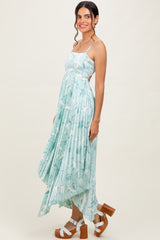 woman wearing a light blue floral print maxi dress with a high-low hem and strappy shoulders
