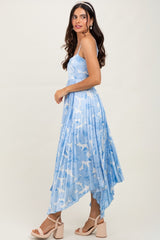 woman wearing a light blue floral midi dress with a pleated design and a high-low hemline