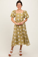 woman wearing an olive green floral midi dress with puff sleeves and a square neckline