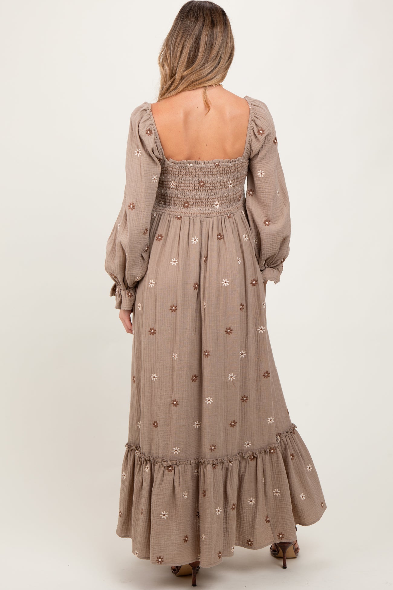 maternity wear long sleeve maxi dress in beige with floral embroidery and smocked bodice, model shown from the back