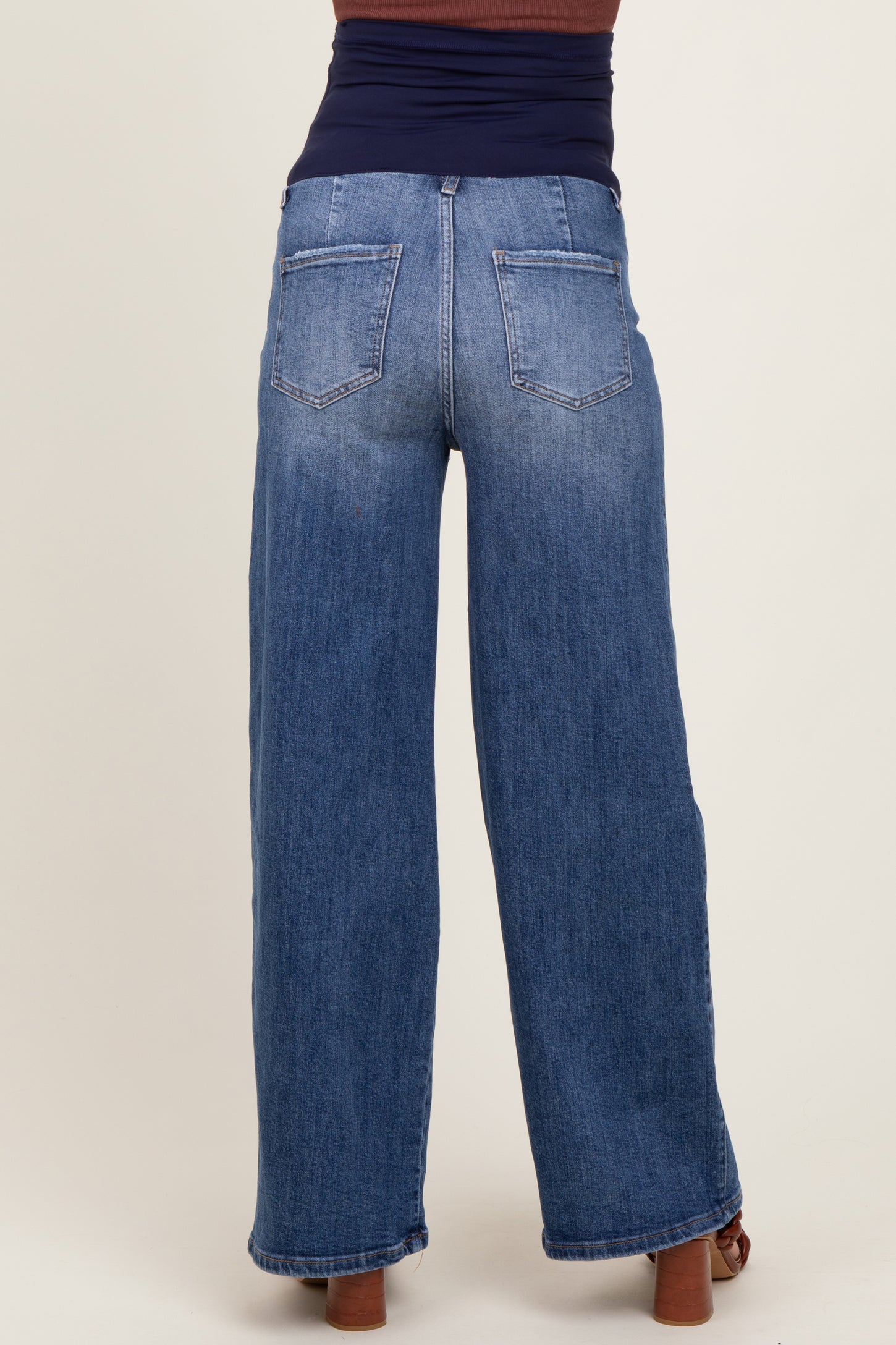 woman wearing a pair of blue wide-leg maternity jeans, showing the back view and a comfortable fit
