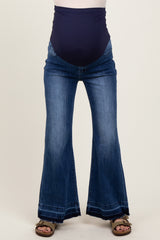 woman wearing dark wash flared maternity jeans with a supportive belly band and ankle detailing