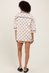 woman wearing a white and black patterned oversized shirt with short sleeves and a relaxed fit