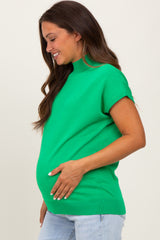 woman wearing a green short sleeve maternity top and showing her baby bump