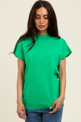woman wearing a bright green short sleeve top with a high neckline and relaxed fit