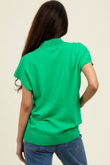 woman wearing a green short sleeve sweater with a ribbed hem and back view, paired with blue jeans