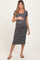 woman wearing a black and white striped maternity dress and holding her baby bump