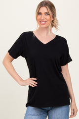 woman wearing a black v-neck t-shirt with short sleeves and relaxed fit, posing with one hand on her hip