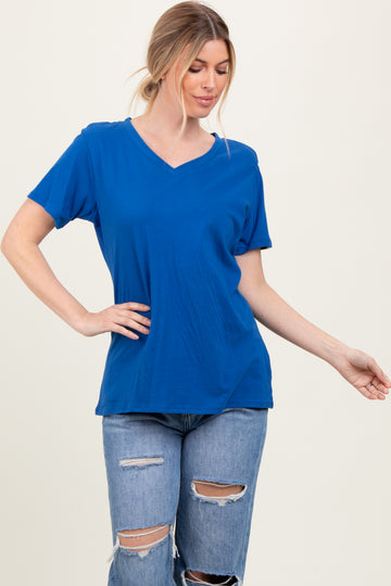 woman wearing a bright blue v-neck t-shirt with short sleeves and relaxed fit, paired with distressed jeans