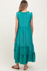 woman wearing a teal sleeveless maternity maxi dress with ruffle details and a tiered skirt, seen from the back