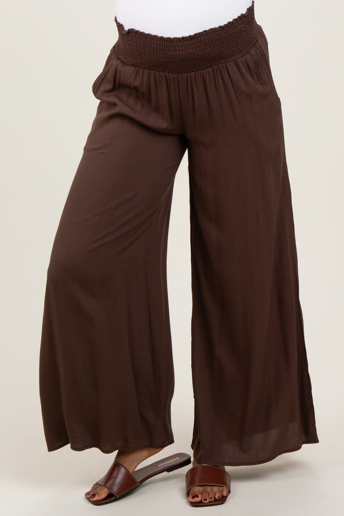 woman wearing dark brown maternity wide-leg pants with a smocked waistband and a relaxed fit