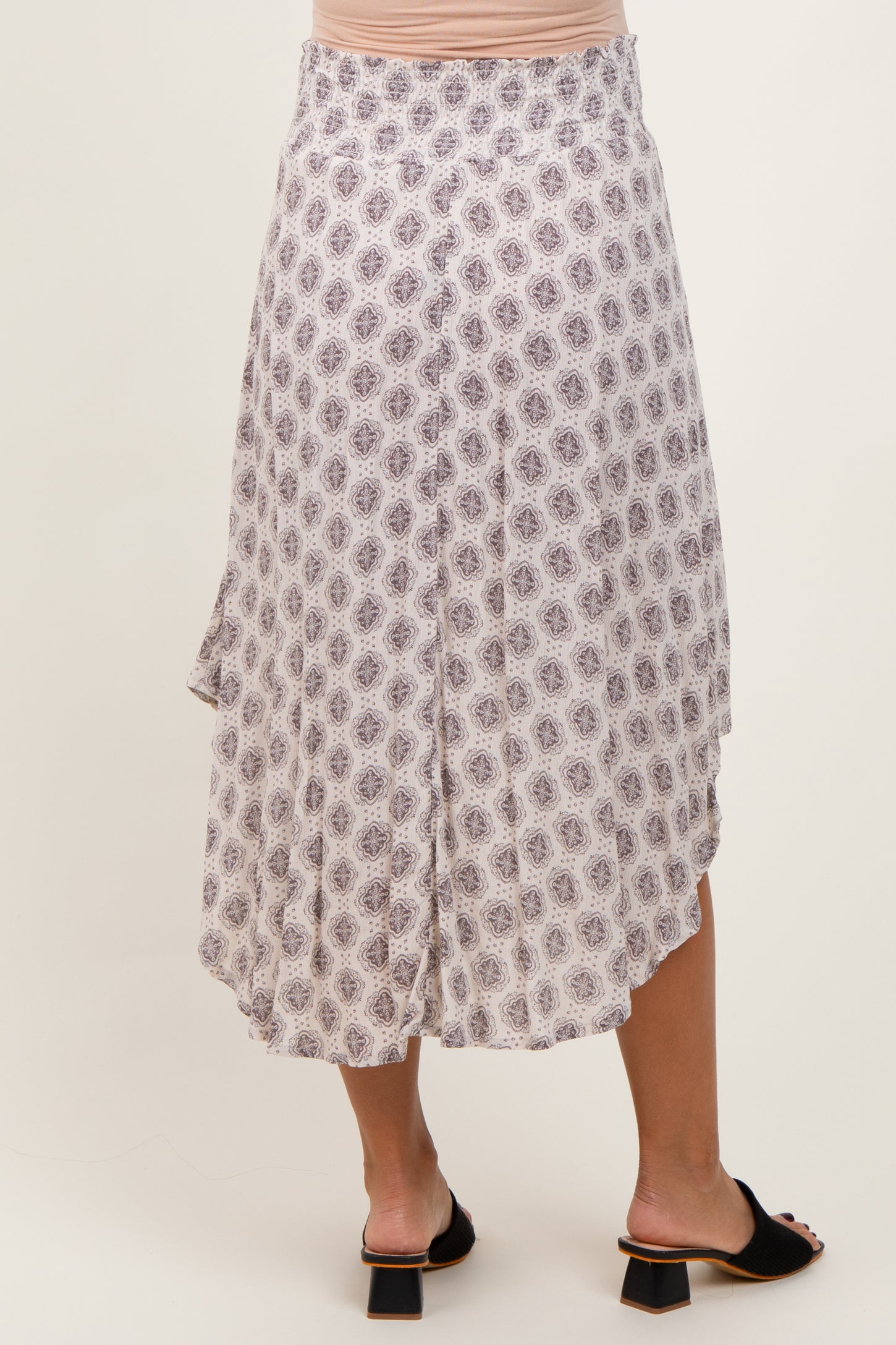 woman wearing a printed asymmetrical maternity skirt with a flowy design and a comfortable waistband