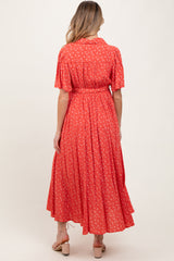 woman wearing a red floral print maternity dress with short sleeves and a tie waist, shown from the back