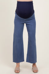 woman wearing dark blue maternity jeans with a stretchy waistband and frayed hem, showcasing her baby bump