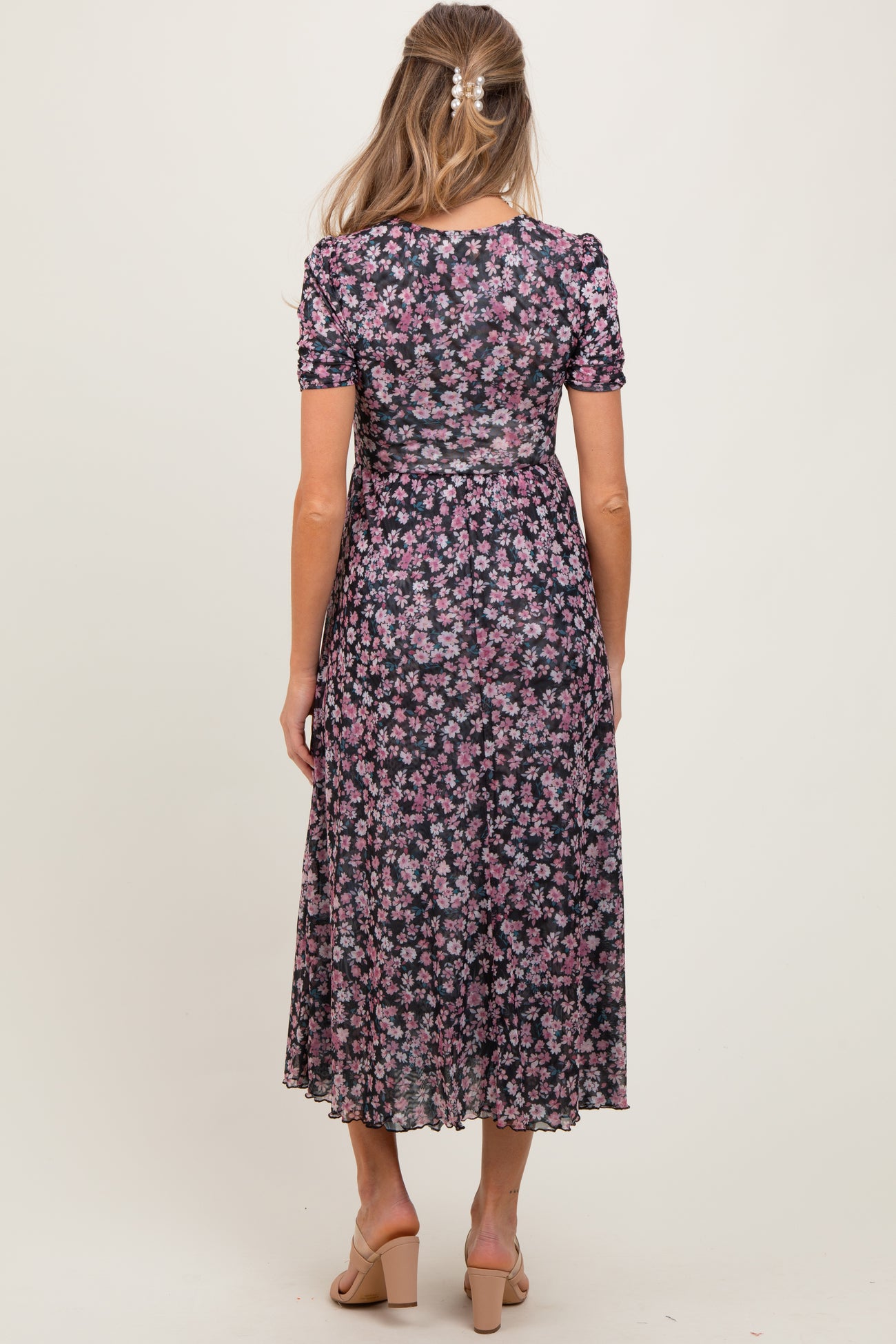 woman wearing a floral print maternity maxi dress with short sleeves and a flowing skirt