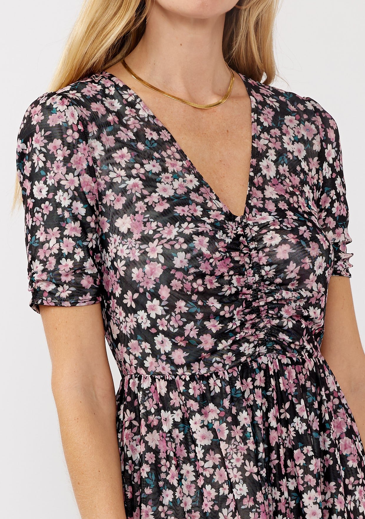 woman wearing a black floral print dress with a V-neckline and short sleeves