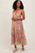 woman wearing a colorful floral maxi dress with a deep V-neck and spaghetti straps