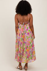 woman wearing a colorful floral maxi dress with a tied back and spaghetti straps