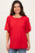 woman wearing a red oversized short sleeve t-shirt with a round neckline and relaxed fit, smiling at the camera