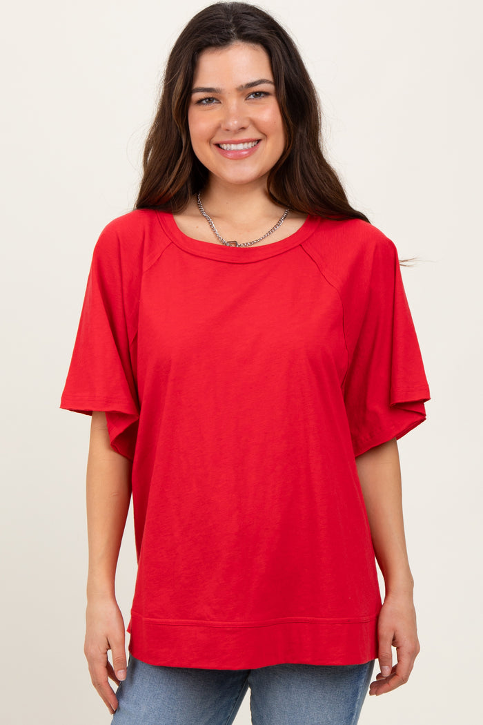 woman wearing a red oversized short sleeve t-shirt with a round neckline and relaxed fit, smiling at the camera