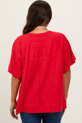 woman wearing a red maternity top with a relaxed fit and short sleeves, showing the back view