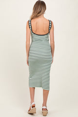 woman wearing a mint green and black striped maternity dress with a fitted style and midi length, showcasing a baby bump from the back