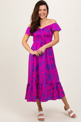 woman wearing a pink off-the-shoulder floral maxi dress with smocking and a ruffled hem